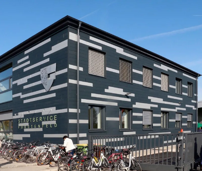 Gebäude des Stadtservice Fürstenfeld mit dunkler Fassade und hellen Streifen
