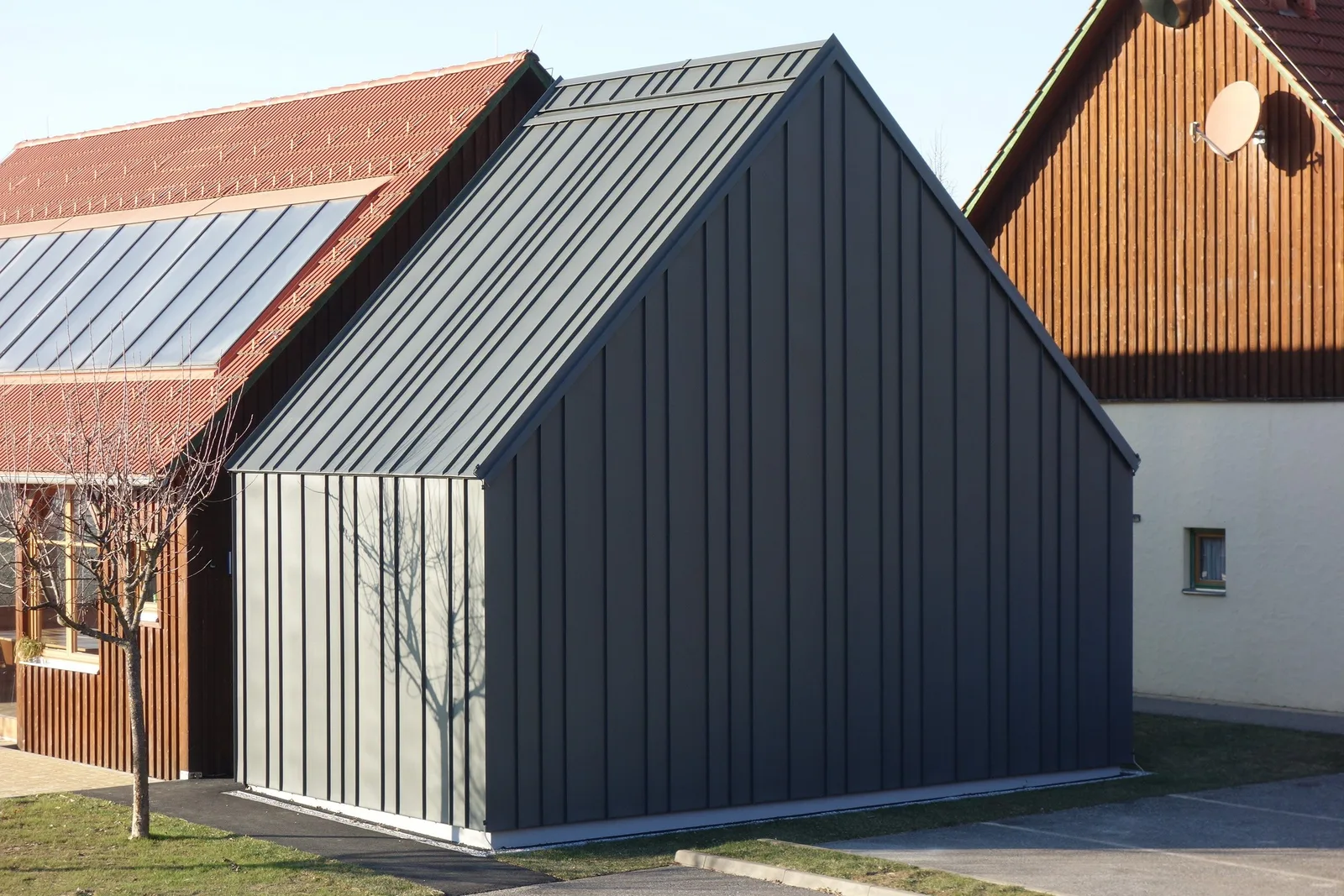 Grauer Anbau, Dach und Fassade mit senkrechten Bahnen