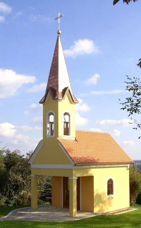 Kapelle mit kupferverkleidetem Turmhelm vor blauem Himmel