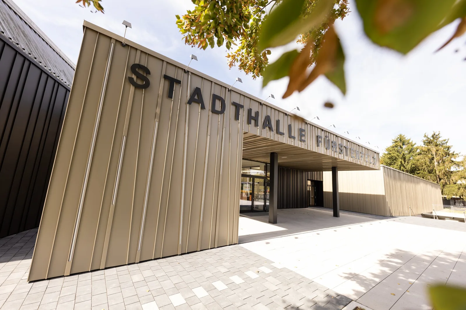 Stadthalle Fürstenfeld, Eingang mit beiger Fassade und Schriftzug