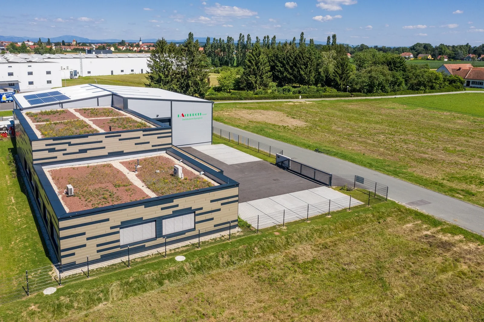 Firmensitz der Dachprofi GmbH von oben, begrünte Flachdächer auf dem Bürotrakt und Halle mit Photovoltaik